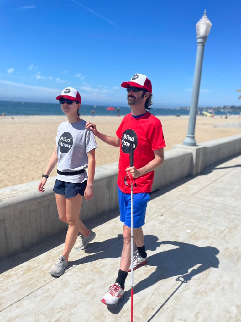 Blind runner and guide walking along Santa Barbara waterfront.